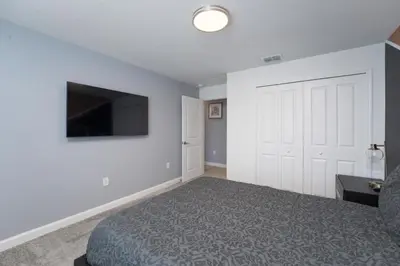 a bedroom with a bed and a flat screen tv at Luxury 4 bedroom 3 bath pool Home 271 in Kissimmee
