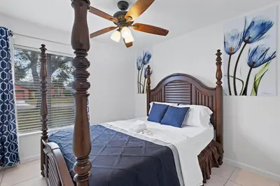 a bedroom with a bed with a ceiling fan at APluSS Getaway in Kissimmee