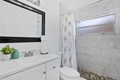 a white bathroom with a toilet and a shower at APluSS Getaway in Kissimmee