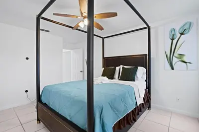 a bedroom with a bed with a ceiling fan at APluSS Getaway in Kissimmee