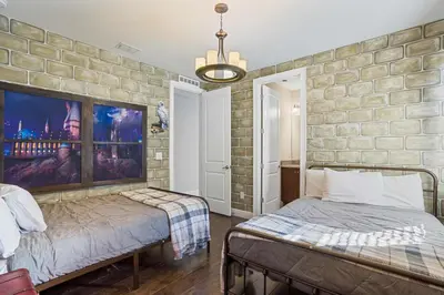 a bedroom with two beds and a stone wall at Willow Cove in Orlando