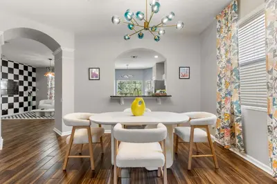 a dining room with a white table and chairs at The Colorful Cove in Orlando