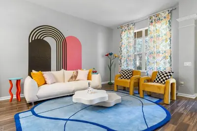 a living room with a couch and a blue rug at The Colorful Cove in Orlando