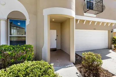 a house with a driveway and a garage at Luxury Emerald Island Resort Villa with Stunning Pool Deck and Lake View Near Disney in Kissimmee