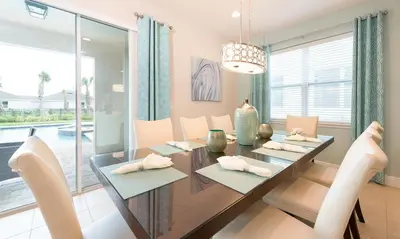 a dining room with a wooden table and chairs at 7412 MA - Stylish Home Near Parks in Orlando