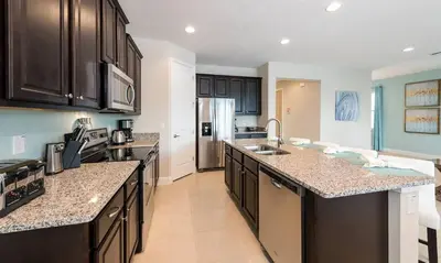 a kitchen with black cabinets and granite counter tops at 7412 MA - Stylish Home Near Parks in Orlando