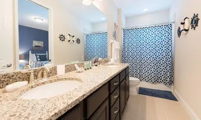 a bathroom with a sink and a toilet and a mirror at 7412 MA - Stylish Home Near Parks in Orlando