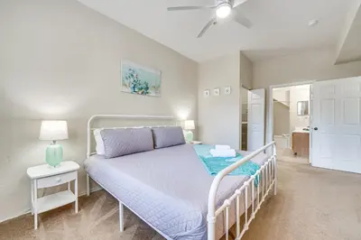 a bedroom with a bed with a white bed frame at 14 Mi to Disney World Kissimmee Condo with Perks! in Kissimmee