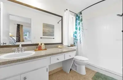 a bathroom with a sink and a toilet and a mirror at Cozy Home Near Disney With Private Pool in Kissimmee