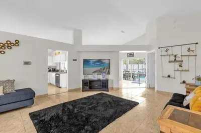 a living room with a blue couch and a kitchen at Cozy Home Near Disney With Private Pool in Kissimmee