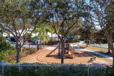a playground with a slide in a park with trees at 2306 SP - Disney Paradise 2BR Villa, Near Magic & More in Kissimmee