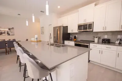 a kitchen with white cabinets and a large counter top at 4BR Villa Private Pool - 11 Guests - Ultimate Family Adventure Awaits in Kissimmee