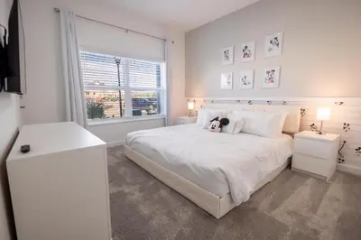a white bedroom with a teddy bear sitting on a bed at 4BR Villa Private Pool - 11 Guests - Ultimate Family Adventure Awaits in Kissimmee