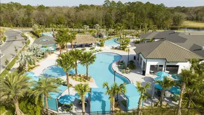 an aerial view of a resort pool with palm trees at 4BR Villa Private Pool - 11 Guests - Ultimate Family Adventure Awaits in Kissimmee