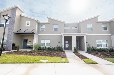 a large apartment building with a driveway at 4BR Villa Private Pool - 11 Guests - Ultimate Family Adventure Awaits in Kissimmee