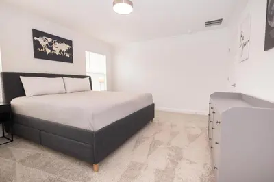 a white bedroom with a bed and a desk at 2604 - Luxury 4-BR Villa with Private Pool Retreat in Kissimmee