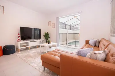 a living room with a couch and a flat screen tv at 2604 - Luxury 4-BR Villa with Private Pool Retreat in Kissimmee