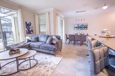 a living room with a couch and a table at 2901 SS Discover Opulence 4-Bedroom Villa with Pool, and Magical Themed Rooms! in Kissimmee