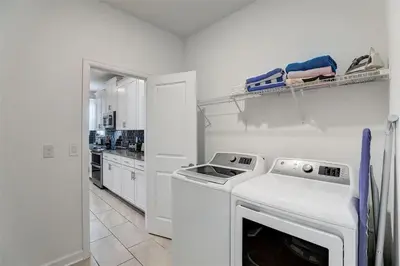 a white kitchen with a stove and a dishwasher at 2940 - Elegant 5BR Villa at Storey Lake Resort Comfort Luxury and Proximity Disney and Universal in Kissimmee