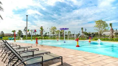 a swimming pool with chairs and a water park at 2940 - Elegant 5BR Villa at Storey Lake Resort Comfort Luxury and Proximity Disney and Universal in Kissimmee
