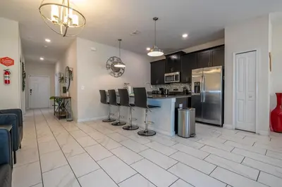a kitchen with black cabinets and a white tile floor at Opulent 5 BR Villa Private Pool - 12 Guests - 3085 TS in Kissimmee