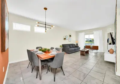 a dining room and living room with a table and chairs at Luxury 3-Bed Condo in Storey Lake Resort - 3131 in Kissimmee