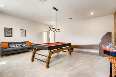 a living room with a pool table and a couch at Stunning 6BR Home, Private Pool & Spa - 14 Guests - 4507 NL in Kissimmee