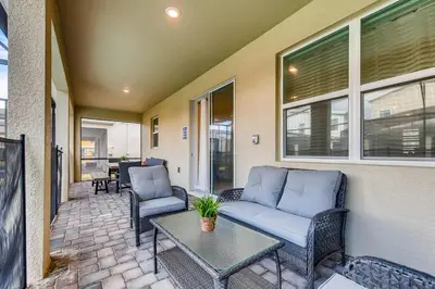 a patio with a couch and chairs and a table at Stunning 6BR Home, Private Pool & Spa - 14 Guests - 4507 NL in Kissimmee