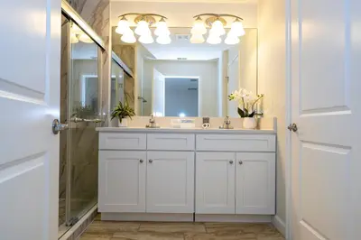 a bathroom with a white sink and a mirror at 4812 BR - Enchanted Lakeside Escape Luxurious Family Retreat in Kissimmee