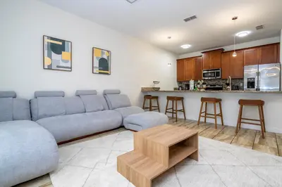 a living room with a couch and a kitchen at 4812 BR - Enchanted Lakeside Escape Luxurious Family Retreat in Kissimmee