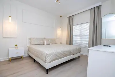 a white bedroom with a bed and a window at 4812 BR - Enchanted Lakeside Escape Luxurious Family Retreat in Kissimmee
