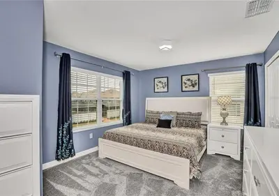 a bedroom with blue walls and a bed and a window at Stunning Townhome with Private Pool - Storey Lake - 5021 WW in Kissimmee