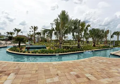 a swimming pool with palm trees in a resort at Stunning Townhome with Private Pool - Storey Lake - 5021 WW in Kissimmee
