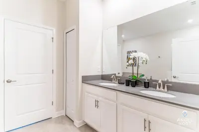 a bathroom with two sinks and a large mirror at In-Home Arcade, Themed Bedrooms, Resort Lazy River in Kissimmee