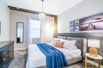 a bedroom with a bed with a blue blanket on it at In-Home Arcade, Themed Bedrooms, Resort Lazy River in Kissimmee