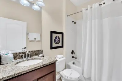 a bathroom with a sink and a toilet and a shower at 9008 Paradise Palms Blissful Haven 5-Bed Oasis of Luxury and Tranquility in Orlando