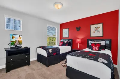 a bedroom with two beds and a red wall at 9008 Paradise Palms Blissful Haven 5-Bed Oasis of Luxury and Tranquility in Orlando