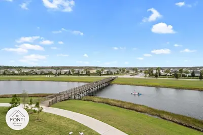 a boat on a river with a bridge at Modern Storey Lake Resort Disney Orlando 3120-105 in Kissimmee
