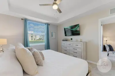 a bedroom with a white bed and a window at Modern Storey Lake Resort Disney Orlando 3120-105 in Kissimmee