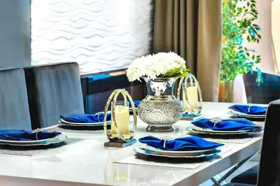 a table with blue plates and a vase of flowers at Resort Home near Disney Themed Jacuzzi Pool 2609 in Orlando