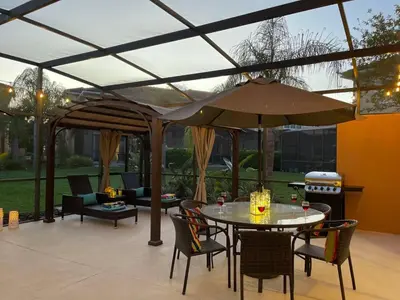 a patio with a table and an umbrella at Resort Home by Disney Themed Jacuzzi Pool 2666 in Orlando
