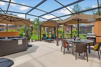 a patio with a table and chairs and a grill at Resort Home by Disney Themed Jacuzzi Pool 2666 in Orlando
