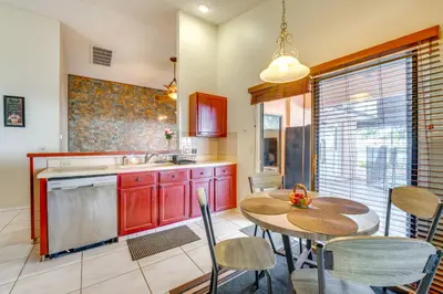 a kitchen with red cabinets and a table and chairs at Furnished Lanai and Lake View Quiet Home in Orlando in Kissimmee