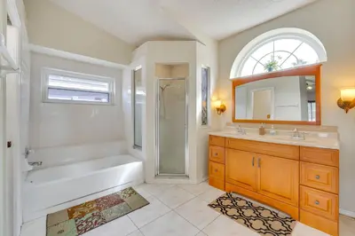 a bathroom with a tub and a shower and a sink at Furnished Lanai and Lake View Quiet Home in Orlando in Kissimmee