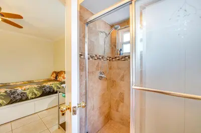 a bathroom with a shower and a bed at Furnished Lanai and Lake View Quiet Home in Orlando in Kissimmee