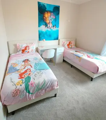 a bedroom with two beds and a desk and a painting at Beautiful Apartment Near Disney in Kissimmee