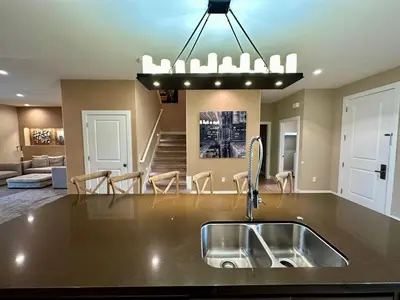 a kitchen with a sink and a living room at Luxury Home 7 Min Disney Universal 3BR4BA - Hot Tub in Orlando