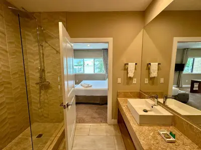 a bathroom with a sink and a shower and a bed at Luxury Home 7 Min Disney Universal 3BR4BA - Hot Tub in Orlando