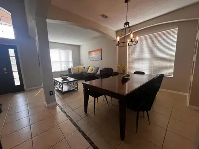 a dining room and living room with a table and chairs at Charming Family Friendly Home in Kissimmee
