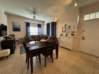 a dining room and living room with a table and chairs at 4 Bedroom 3 Bathroom Villas At SevenDwarfs 31-107 in Kissimmee